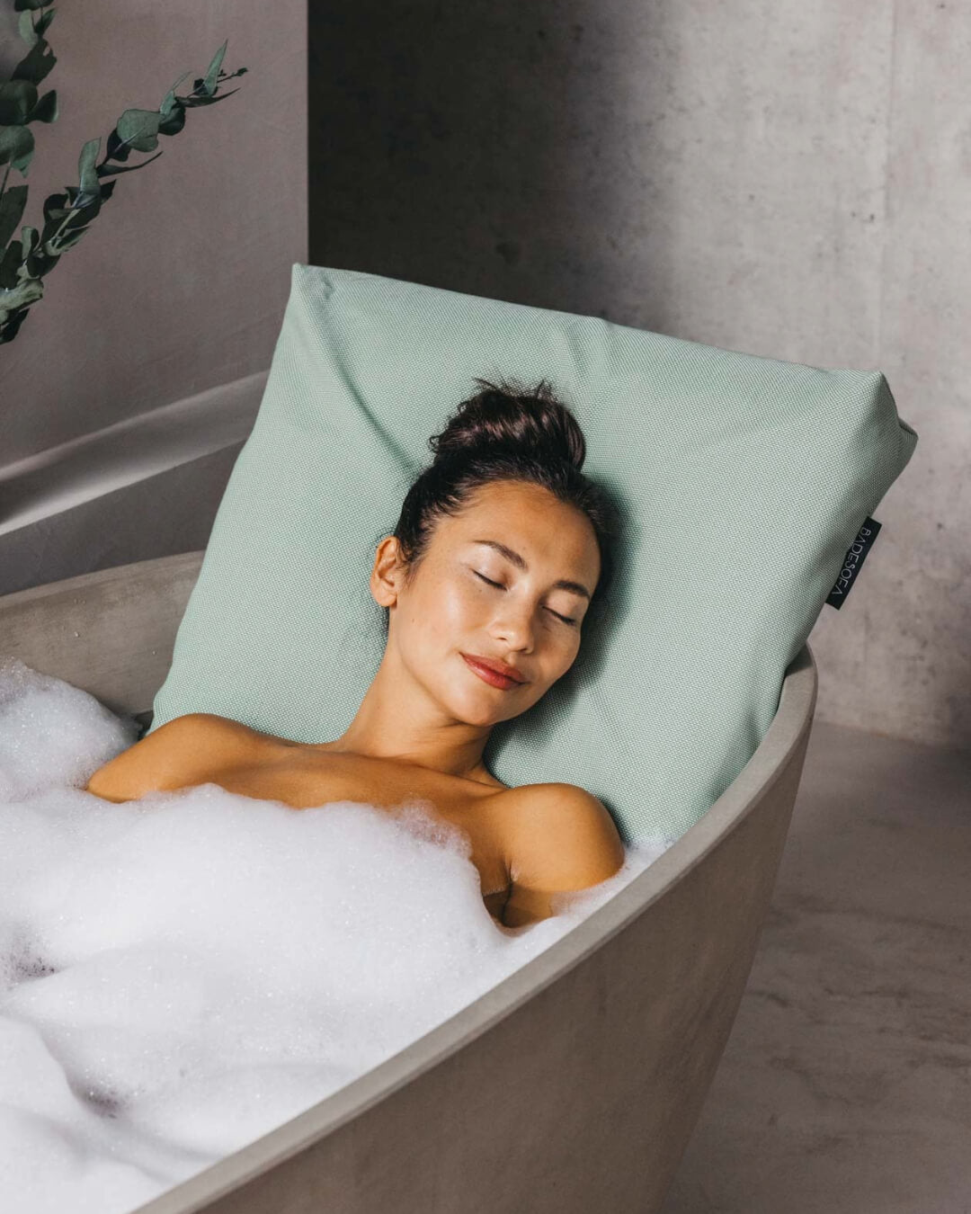 Frau badet mit Badesofa Rückenkissen (Farbe Grün / Größe Large) in freistehender, großer Badewanne